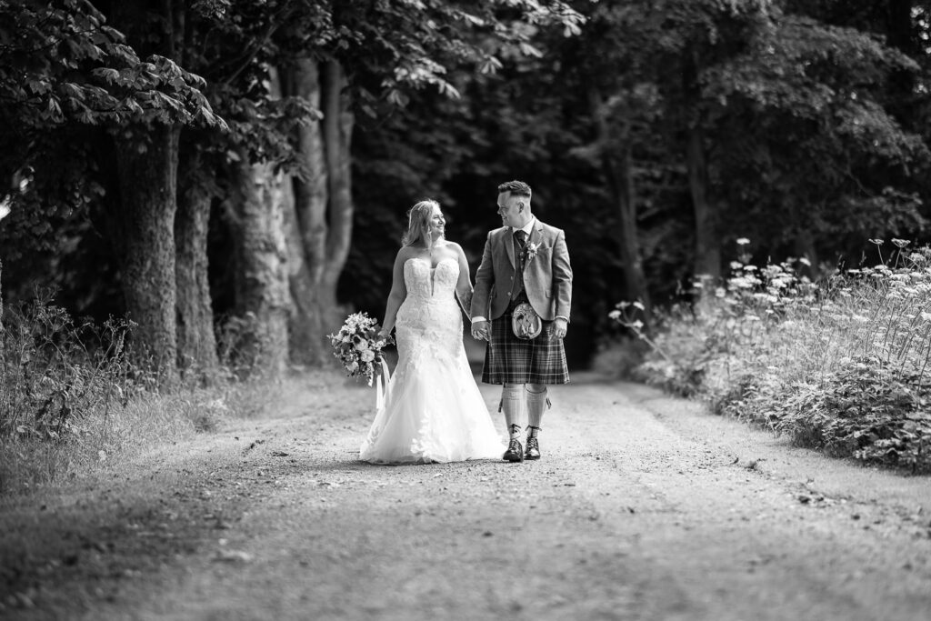 black and white photo at kinkell byre bride and groom portrait against the red barn doors