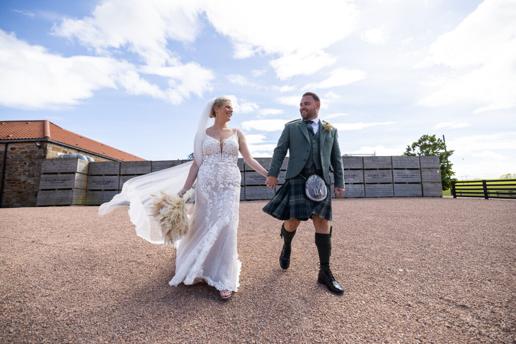 wide angle of bride and groom walking