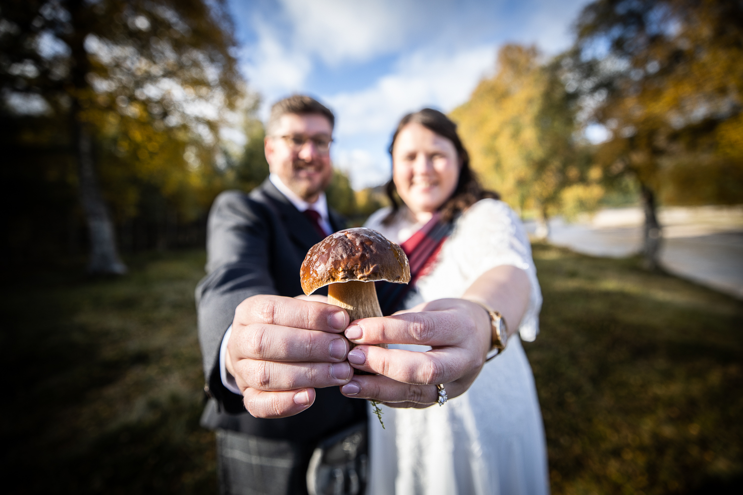 couple portrait of bride & groom holding a mushroom close up