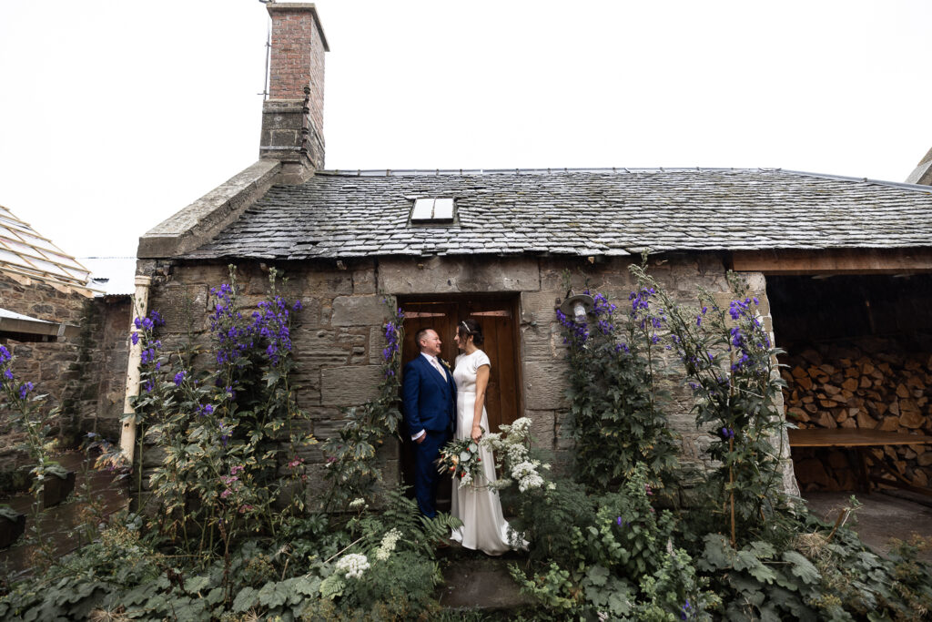 couple portrait standing in a rustic doorway at The Free Company