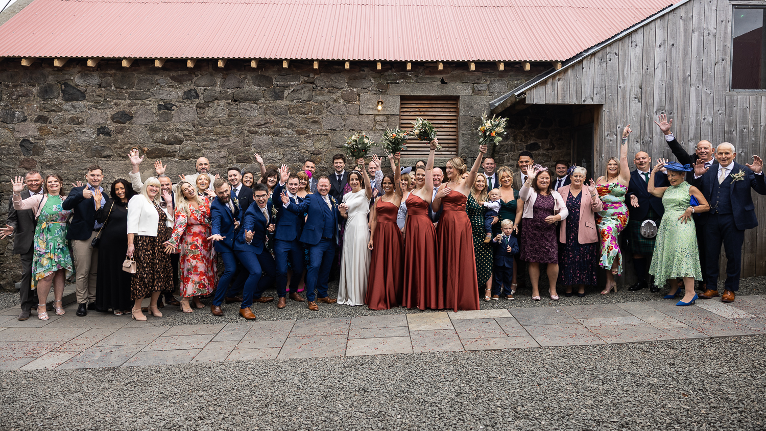 big group in the courtyard holding hands up